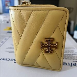 Elegant Tory Burch wallet, gold quilted leather. Features signature logo detail.